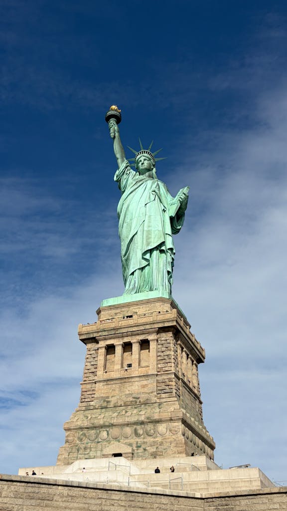 The iconic Statue of Liberty against a clear blue sky in New York City, symbolizing freedom and democracy.